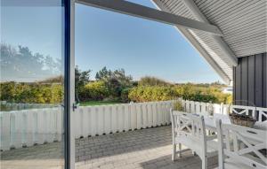 a patio with two white benches on a white fence at Lovely Home In Vestervig With Wifi in Vestervig