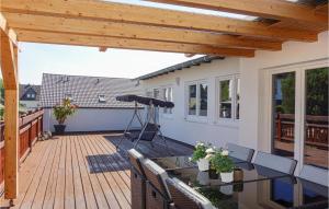 a patio with a wooden deck with a table and chairs at Nice Home In Schmallenberg With Wifi And 5 Bedrooms in Schmallenberg