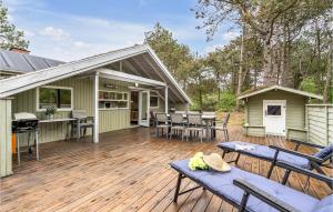 a deck with chairs and a grill on a house at Stunning Home In Rm With Kitchen in Bolilmark