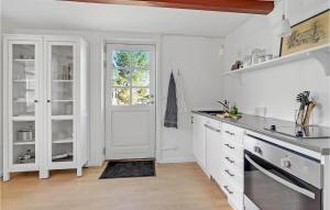 una cucina con armadietti bianchi e una finestra di Stunning Apartment In Nørre Alslev a Nørre Alslev Altre 11 foto