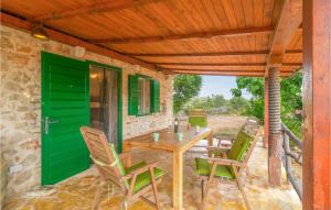 a table and chairs on a patio with a green door at Beautiful Home In Stari Grad With Wifi in Stari Grad