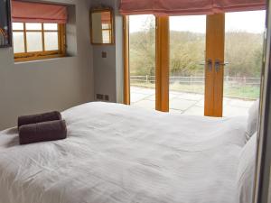 een groot wit bed in een kamer met een raam bij The Hen House in Bodiam