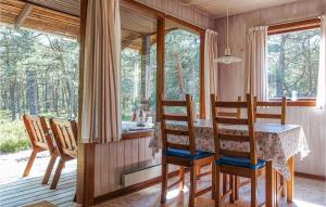 ein Esszimmer mit Tisch und Stühlen und Fenstern in der Unterkunft 3 Bedroom Beautiful Home In Nexø in Neksø