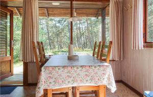 ein Esszimmer mit Tisch und Stühlen und einem Fenster in der Unterkunft 3 Bedroom Beautiful Home In Nexø in Neksø