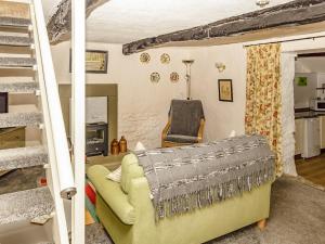 シャップにあるPrimrose Cottageのリビングルーム(黄色のソファ、階段付)