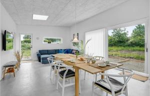 哈德斯萊夫的住宿－Amazing Home In Haderslev With Kitchen，用餐室以及带桌椅的起居室。