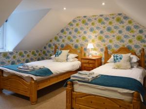 two twin beds in a room with a attic at Mercy Cottage - Beaufort Estate in Belladrum