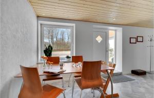 une salle à manger avec un plafond en bois, une table et des chaises dans l'établissement Lovely Apartment In Kibk With Kitchenette, à Kibæk