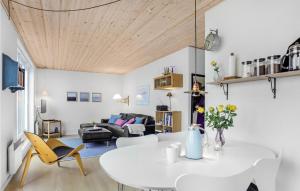 ein Wohnzimmer mit einem weißen Tisch und Stühlen in der Unterkunft Amazing Apartment In Gudhjem With Kitchen in Gudhjem