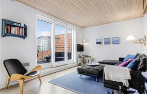 ein Wohnzimmer mit einem Sofa, Stühlen und einem Fenster in der Unterkunft Amazing Apartment In Gudhjem With Kitchen in Gudhjem