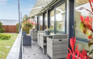 une terrasse avec des chaises en osier et une table. dans l'établissement 1 Bedroom Beautiful Home In Otterndorf, à Otterndorf