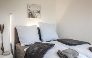 - un lit avec des oreillers bleus et blancs dans l'établissement 1 Bedroom Beautiful Home In Otterndorf, à Otterndorf