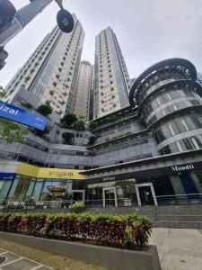 a large building with two tall buildings at Muggle Stay Guest House - Bonifacio Global City Taguig in Manila