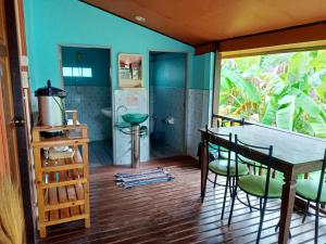 a kitchen with a table and chairs and a refrigerator at Patcharin Homestay in Ban Lo Pla Lai (1)