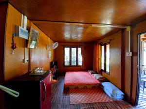 a small room with a bed in the back of a train at Patcharin Homestay in Ban Lo Pla Lai (1)