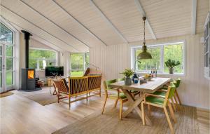 een eetkamer met een tafel en stoelen en een open haard bij Awesome Home In Rrvig With Kitchen in Rørvig
