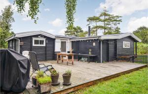 ein schwarzes winziges Haus mit einer Holzterrasse in der Unterkunft Stunning Home In Anholt With Wifi in Anholt
