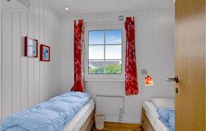 a room with two beds and a window with red curtains at Awesome Home In Ebberup With Wifi in Ebberup