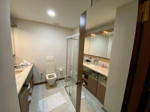 uma casa de banho com um WC, 2 lavatórios e um chuveiro em ELİT SUİT em Istambul