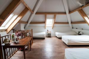 a attic room with two beds and a table at Farm Overleekerhoeve in Monnickendam