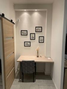 una habitación con una mesa con una silla y cuadros en la pared en Appartement au pied de la gare, en Noisy-le-Sec
