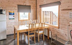 comedor con mesa, sillas y nevera en Lovely Home In Vetlanda With House Sea View en Vetlanda