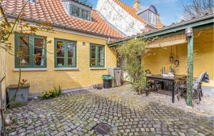 里伯的住宿－Beautiful Home In Ribe With Wifi，黄色房子前面有桌子