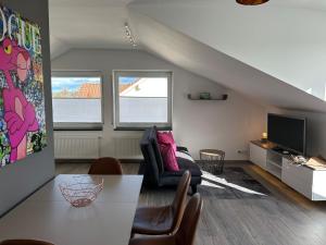a living room with a couch and a tv at Timeless - die Ferienwohnung in Wasserburg in Bettnau
