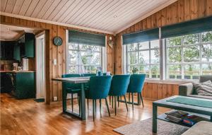 a dining room with a table and blue chairs at Beautiful Home In Engerdal With Kitchen 