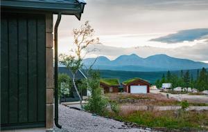 a green building with mountains in the background at Beautiful Home In Engerdal With Kitchen 
