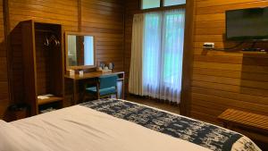 Casa Kandara في وينغابو: غرفة نوم بسرير ومكتب وتلفزيون