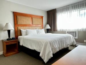 a hotel room with a large bed and a window at Anavada Inn & Suites - Prince George in Prince George