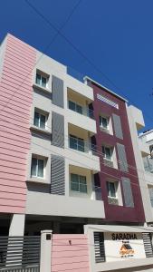 un grand immeuble d'appartements avec des tons roses et blancs dans l'établissement Chippy Apartments No.544, à Chennai
