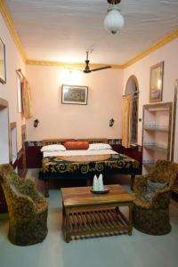 1 dormitorio con 1 cama, 2 sillas y mesa en Kasera Paradise en Būndi
