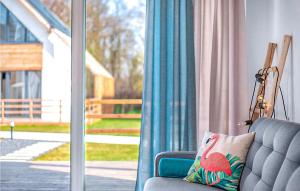 a blue couch sitting in front of a window at Amazing Home In Nowecin With Kitchen in Nowecin