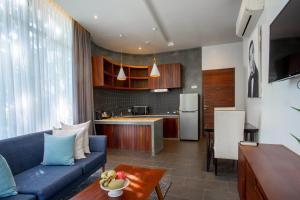 a living room with a blue couch and a kitchen at Maison Leab in Siem Reap