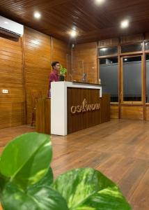 a man standing at a counter in a room with wood at Casa Kandara in Waingapu