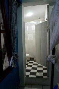 baño con suelo a cuadros en blanco y negro en hostal Monte Libano, en Puerto López