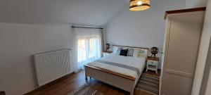 a white bedroom with a bed and a window at Porumbacu381 - Casa de Oaspeti Faini in Porumbacu de Sus +59 photos