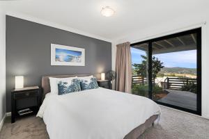 a bedroom with a white bed and a large window at Copacabana 'Chill Out' in Copacabana