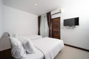 een slaapkamer met 2 bedden en een flatscreen-tv bij Circle Inn Ao Nam Mao in Ao Nam Mao