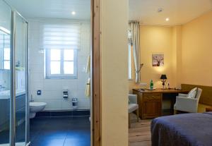 a bedroom with a bathroom with a shower and a toilet at Hotel Zum Harzer in Clausthal-Zellerfeld