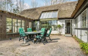 a patio with a table and chairs in front of a house at Beautiful Home In ster Ulslev With Kitchen in Øster Ulslev