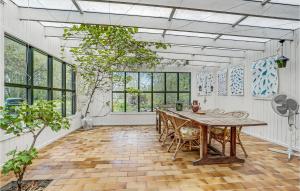 una camera con tavolo e alcune finestre di Beautiful Home In ster Ulslev With Kitchen a Øster Ulslev