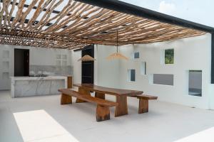 einen Holztisch und eine Bank in einem Zimmer mit Küche in der Unterkunft Lavender Rooftop Villa 3 bedrooms with a private heated swimming pool in Bandung