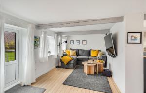 een woonkamer met een bank en een tafel bij Nice Home In rskbing With Kitchen in Ærøskøbing