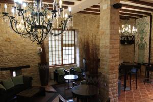 a restaurant with a chandelier and tables and chairs at Hotel Palacio Dos Olivos in Galdeano