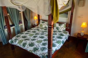 a bedroom with a bed with a canopy at Rischland Villas in Watamu +28 photos