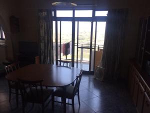 uma sala de jantar com uma mesa e cadeiras e uma janela em Entire apartment with Ramla Bay view (Gozo, Malta) em Il-Pergla