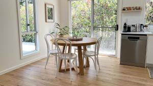 a kitchen with a wooden table and chairs in a kitchen at Honey Fig Cottage, Bowral in Bowral